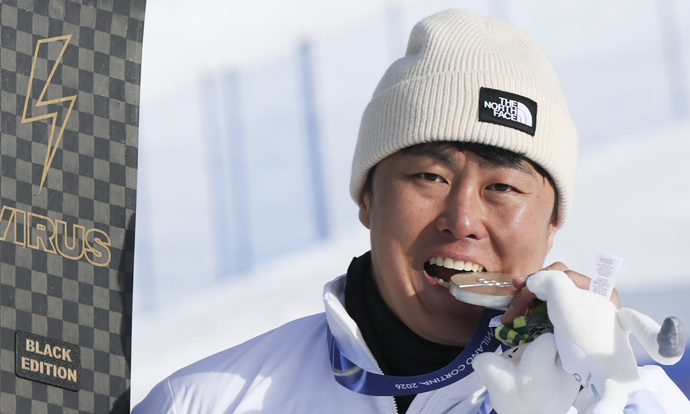 스노보드 은메달리스트 김상겸이 이탈리아 리비뇨 스노우파크에서 열린 2026 밀라노코르티나 담페초 동계올림픽 스노보드 남자 평행대회전 메달 시상식에서 은메달을 입에다 물고 있다. 리비뇨=뉴시스