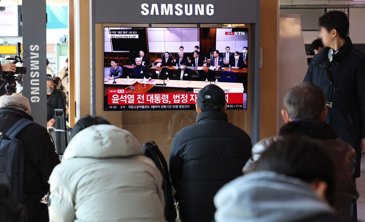 19일 오후 서울 용산구 서울역에서 시민들이 '내란 우두머리 혐의' 윤석열 전 대통령의 1심 선고 공판 중계를 시청하고 있다. 윤 전 대통령은 1심에서 무기징역을 선고 받았다. 뉴시스