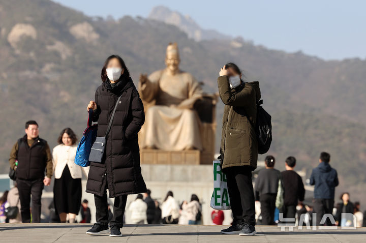황사의 영향으로 서울에 미세먼지 경보가 발령된 22일 서울 종로구 광화문광장에서 마스크를 쓴 관광객들이 이동하고 있다. 뉴시스