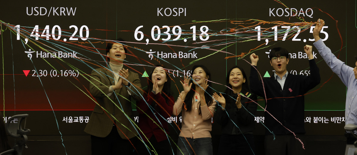 코스피가 장중 6,000을 넘은 25일 오전 서울 중구 하나은행 딜링룸에서 관계자들이 코스피 6000 돌파를 축하하고 있다. 뉴시스