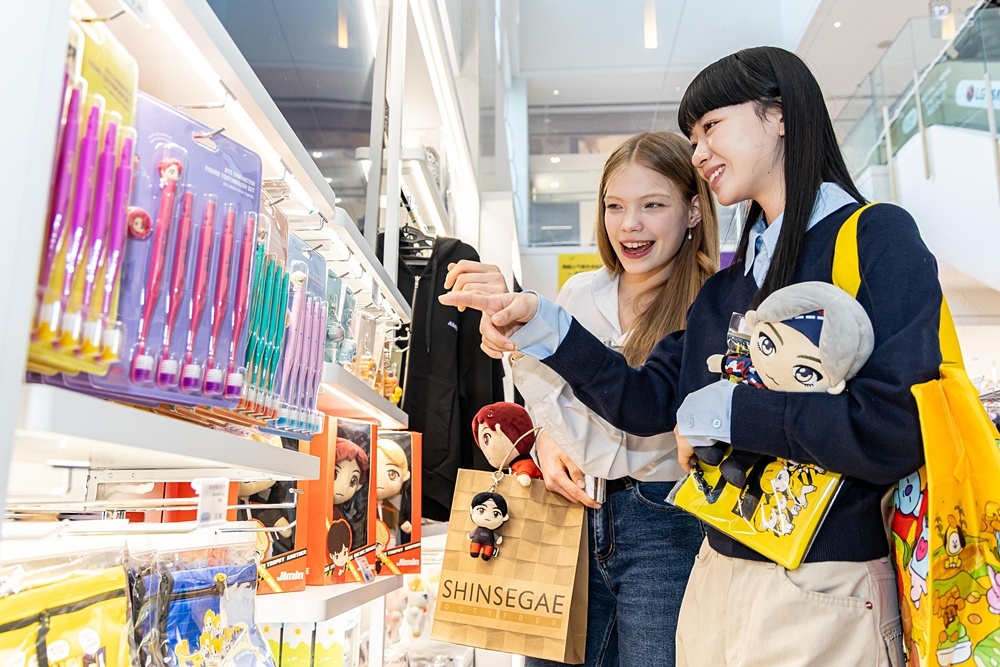 외국인 소비자들이 신세계면세점 명동점 K-웨이브 존에 전시된 방탄소년단(BTS) 굿즈를 살펴보고 있다. 신세계면세점 제공