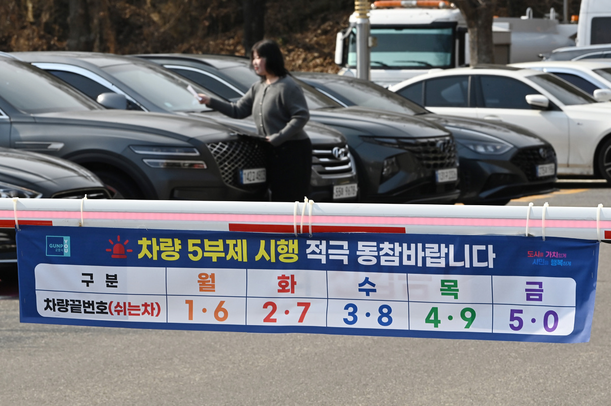 24일 경기 군포시청 주차장에서 직원이 차량 5부제 시행 안내문을 부착하고 있다. 정부는 중동 사태로 원유 수급 위기가 확산되자 내일부터 공공부문에 대한 승용차 5부제를 시행한다. 뉴시스