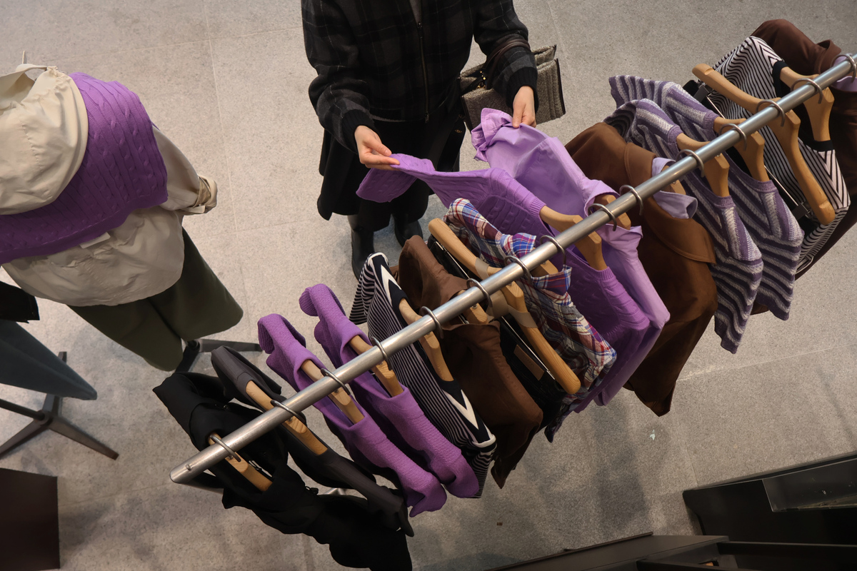 헤지스 플래그십 스토어 스페이스H 내부에 진열된 보라색 의류를 고객이 고르고 있다. LF 제공