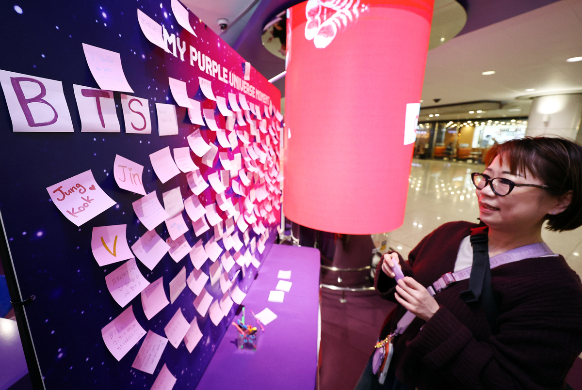 방탄소년단(BTS)의 서울 광화문광장 컴백 공연을 하루 앞둔 20일 인천공항 제1터객미널 교통센터 하이커스테이션에서 BTS 해외팬이 메시지를 적은 메모지를 붙이고 있다. 뉴시스