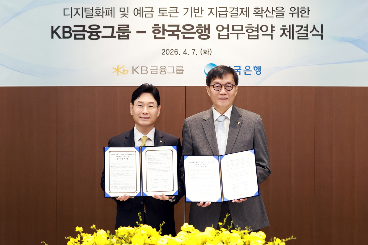 이창권 KB금융지주 미래전략부문장(왼쪽)과 이창용 한국은행 총재가 7일 서울 중구 한국은행 본관에서 진행된 업무협약식에서 기념촬영을 하고 있다. KB금융 제공