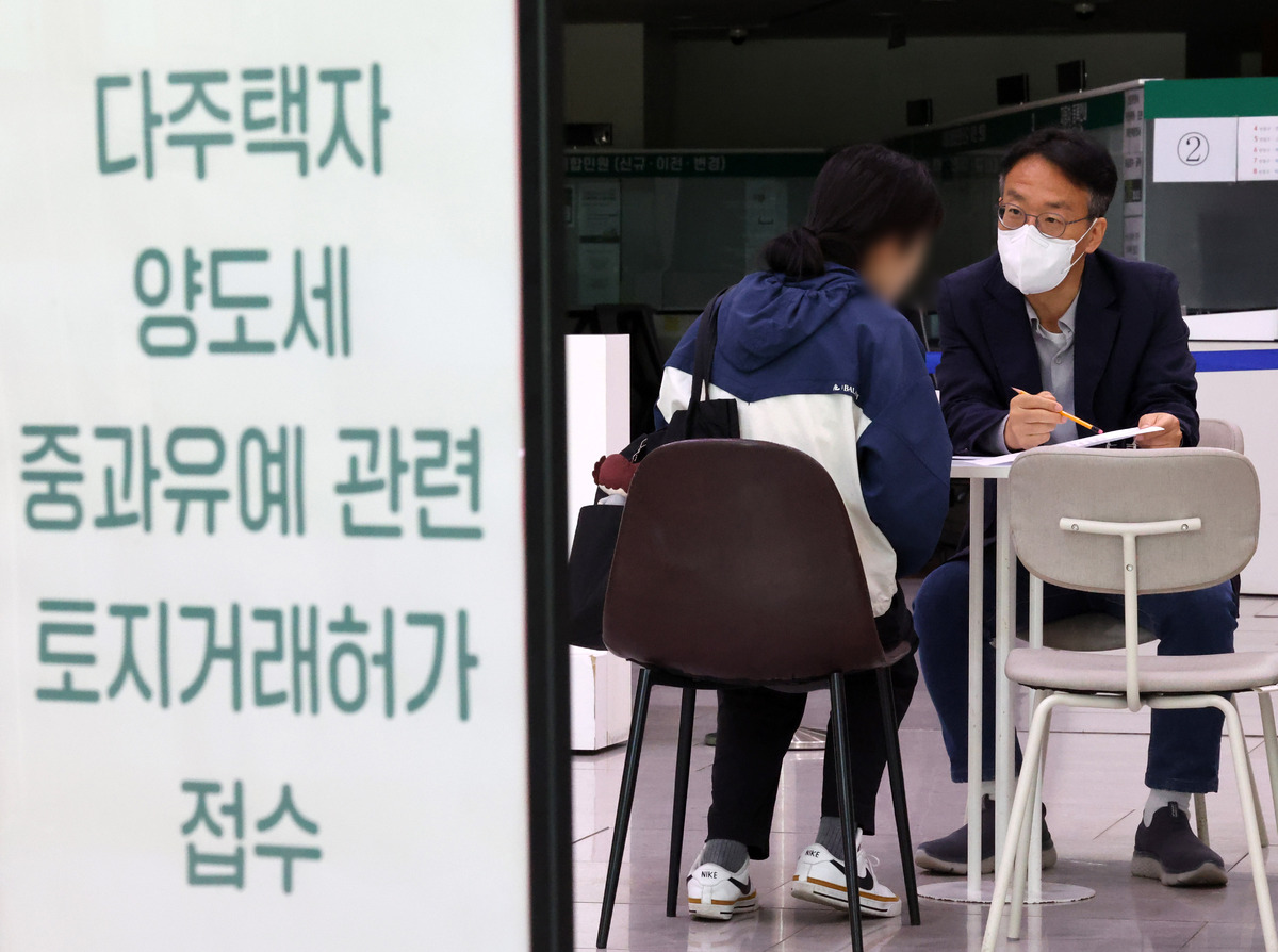 다주택자 양도 소득세 중과 면제 종료일인 지난 9일 오후 서울 송파구청 1층 로비에 마련된 토지거래허가 접수처를 찾은 한 시민이 부동산정보과 담당자와 상담하고 있다. 뉴시스