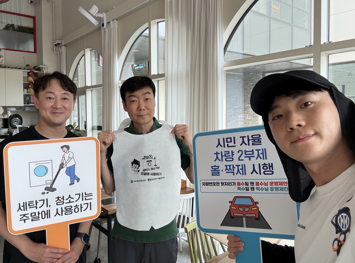 동서발전 임직원과 시민들이 에너지 절약 캠페인 팻말을 들고 기념사진을 찍고 있다. 한국동서발전 제공