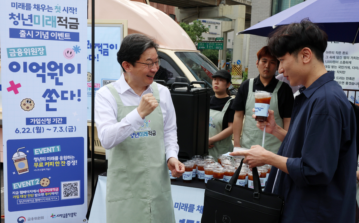 이억원 금융위원회 위원장이 지난 22일 서울 성동구 뚝섬역 인근에서 열린 청년미래적금 출시 기념행사에서 시민에게 커피를 건네며 청년미래적금을 홍보하고 있다. 뉴시스