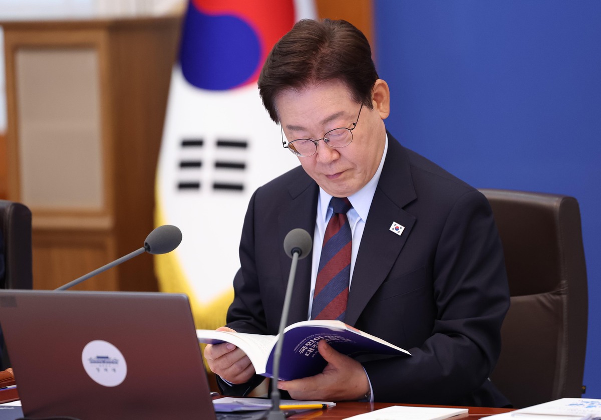 이재명 대통령이 지난 5월 청와대에서 열린 국무회의에서 정부출범 1주년 성과자료집을 살펴보고 있다. 뉴시스
