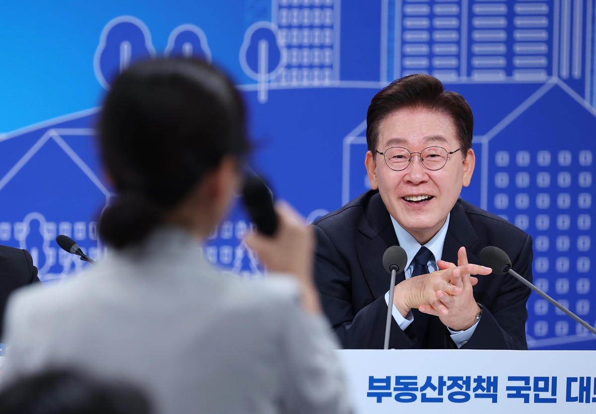 이재명 대통령이 23일 열린 부동산정책 국민 대토론회에서 정부의 부동산 정책이&nbsp;집값을 인위적으로 낮추는 것이 아닌&nbsp;비정상적인 투기 수요를 정상화하는 데 초점을 맞추고 있다고 밝혔다.&nbsp;이재명 대통령이 이날 토론회에서 참석자의 발언을 들으며 미소짓고 있다. 뉴시스