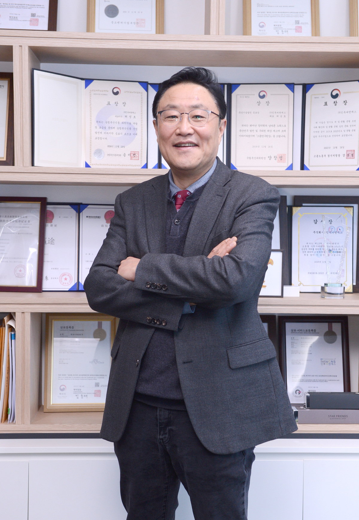 허성호 인투씨엔에스 대표가 그동안 상패와 상장 앞에서 포즈를 취하고 있다. 김두홍 기자