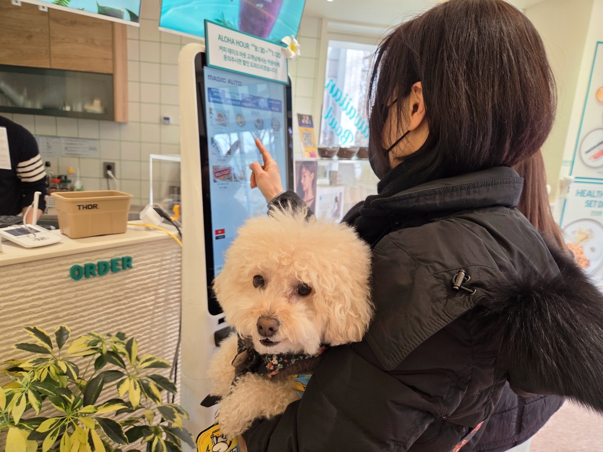 서울 양재천 인근의 한 카페에서 고객이 반려견 루이를 품에 안은 채 메뉴 주문을 하고 있다. 박재림 기자