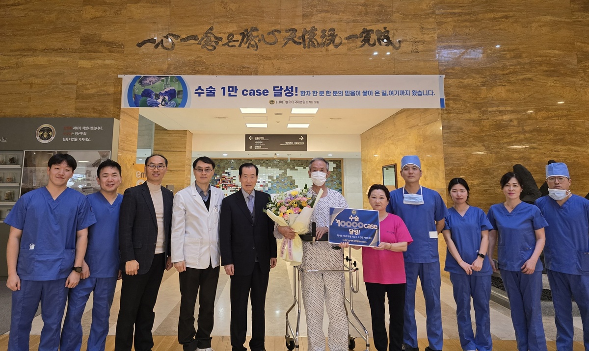 1만번째 환자와 기념촬영한 의료진.&nbsp;왼쪽부터 차준섭 간호사, 김진화 수술팀장, 김형환 사무국장, 김종형 병원장, 이성만 이사장, 민병구님(환자), 간병인, 장우석 정형외과 과장, 임정화 간호사, 사또 마유미 조무사.