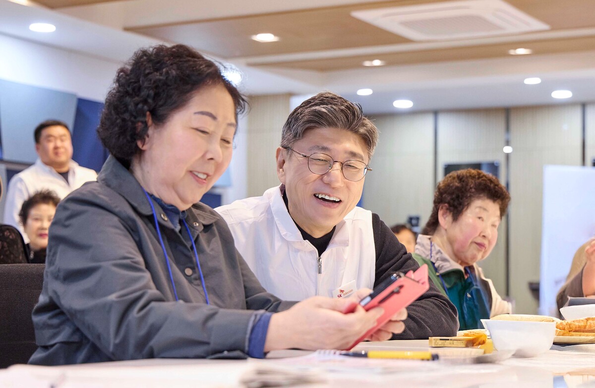 정재헌 SK텔레콤 대표가 지난 27일 경기도 포천시 관인노인대학에서 시니어 고객의 스마트폰을 살펴보고 대화를 나누고 있다. SK텔레콤 제공