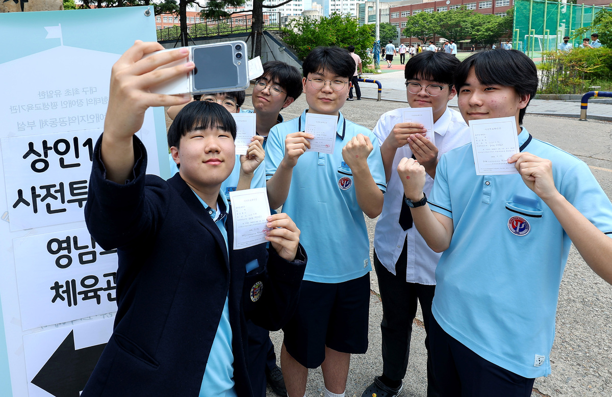 제9회 전국동시지방선거 사전투표 첫날인 29일 대구 달서구 영남고등학교 체육관에 마련된 상인1동 사전투표소에서 투표를 마친 영남고 3학년 학생들이 투표확인증을 들고 인증사진을 찍고 있다. 뉴시스