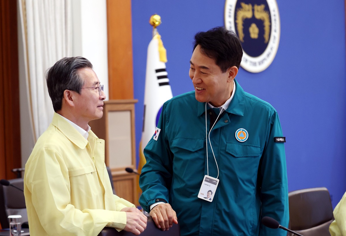 오세훈 서울시장(오른쪽)과 김용범 정책실장이 18일 청와대에서 열린 제1회 을지국무회의에 참석해 대화하고 있다. 뉴시스