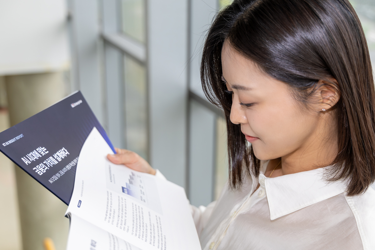 KT 모델이 AX 인사이트 리포트를 살펴보고 있다. KT 제공
