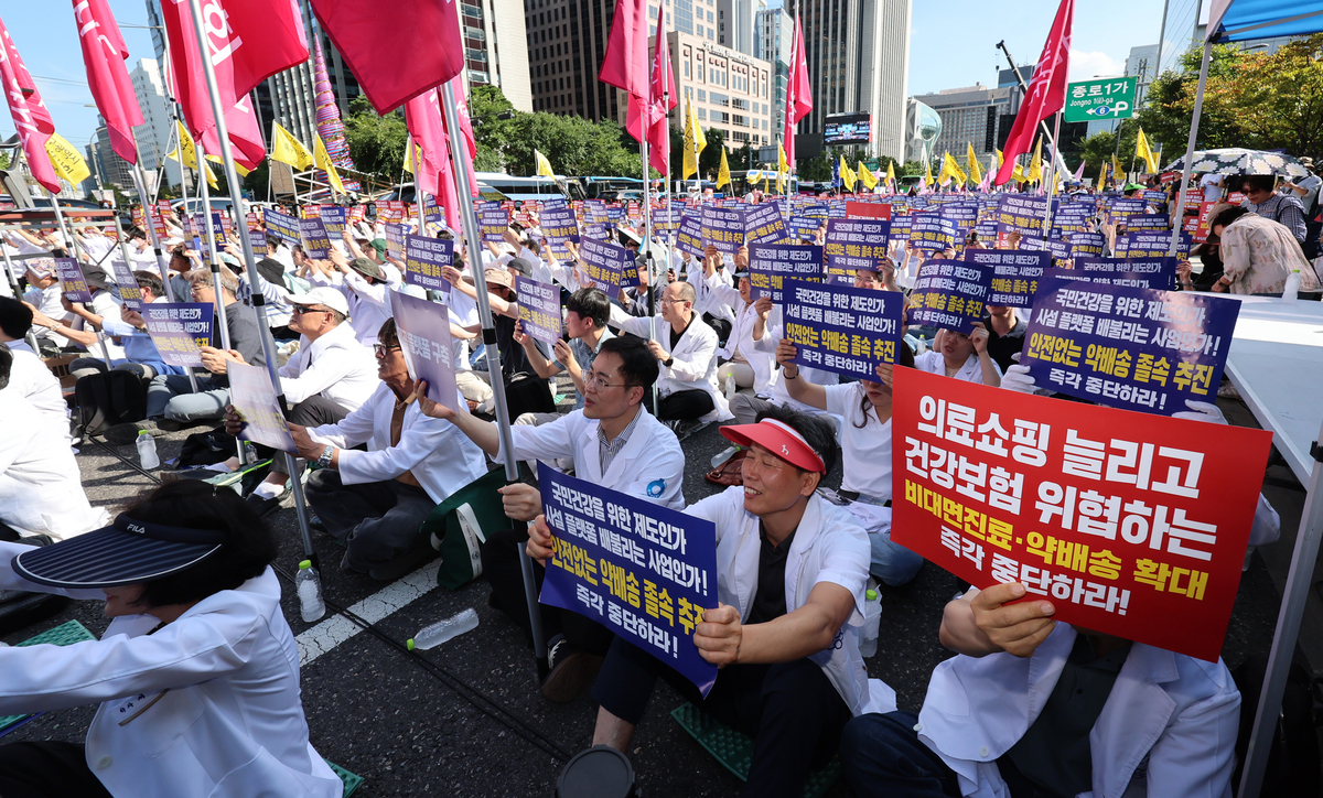 대한약사회 회원들이 20일 서울 종로구 동화면세점 앞에서 열린 국민건강·건강보험 수호 전국 약사 총궐기대회에서 구호를 외치고 있다. 뉴시스