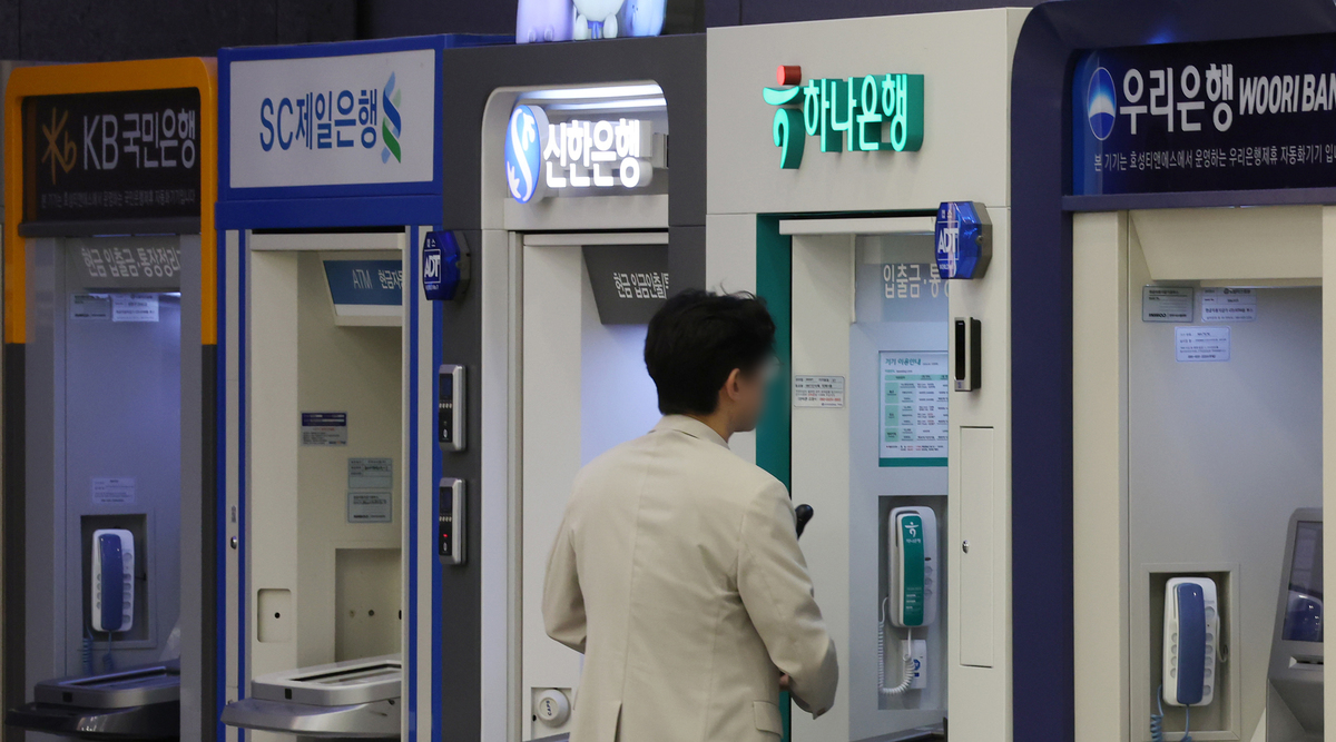 서울 시내의 한 건물에 시중은행 ATM기기에서 한 시민이 업무를 보고 있다. 뉴시스