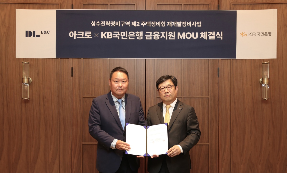 지난 29일 서울 성동구 ‘디타워 서울포레스트’에 위치한 아크로 라운지에서 채준환 DL이앤씨 주택사업본부 도시정비사업 담당임원(왼쪽)이 이원종 KB국민은행 CIB영업그룹 부행장과 ‘성수2지구를 위한 하이엔드 금융 업무협약(MOU)’을 체결한 뒤 기념 촬영을 하고 있다. DL이앤씨 제공