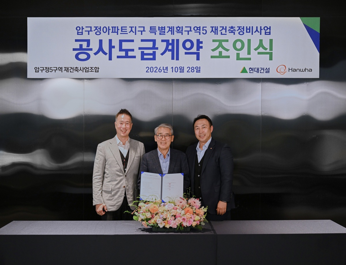압구정5구역 안양호 조합장(가운데)과 현대건설 신국현 상무(왼쪽), 한화 우재희 상무(오른쪽)가 공사도급계약을 체결하고 기념사진을 촬영하고 있다. 현대건설 제공